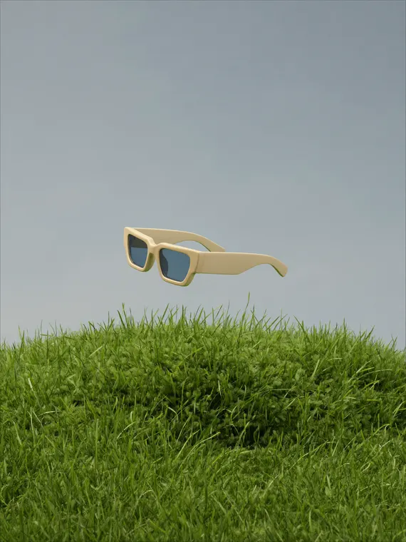 Bag and accessories product photography: sunglasses floating over the grass mound