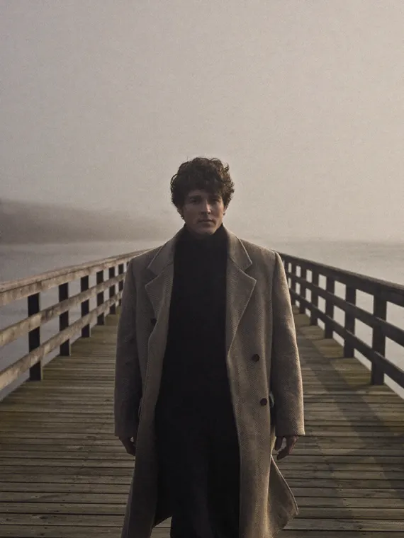 AI fashion model shoot: menswear, camel coat on the foggy pier