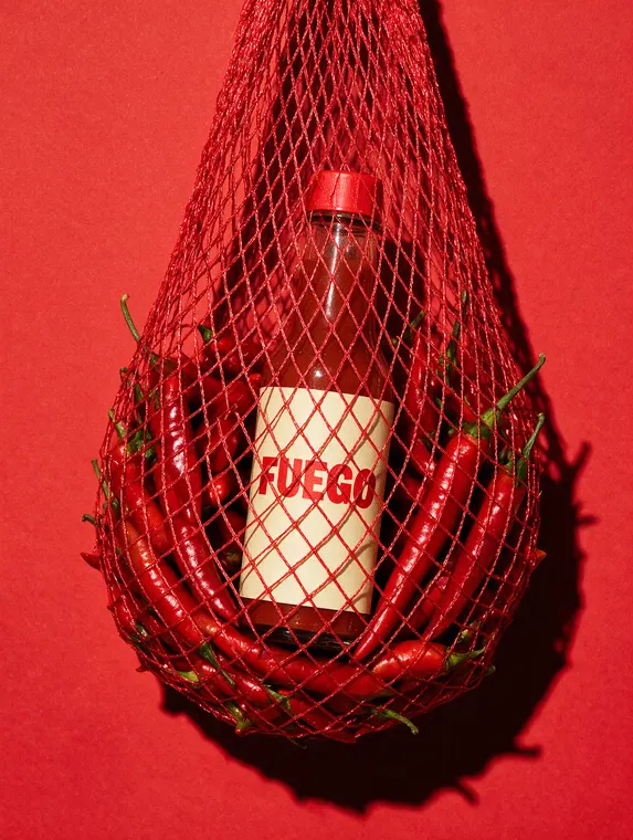 Food and beverage product photography: Fuego hot sauce, net bag of chillies